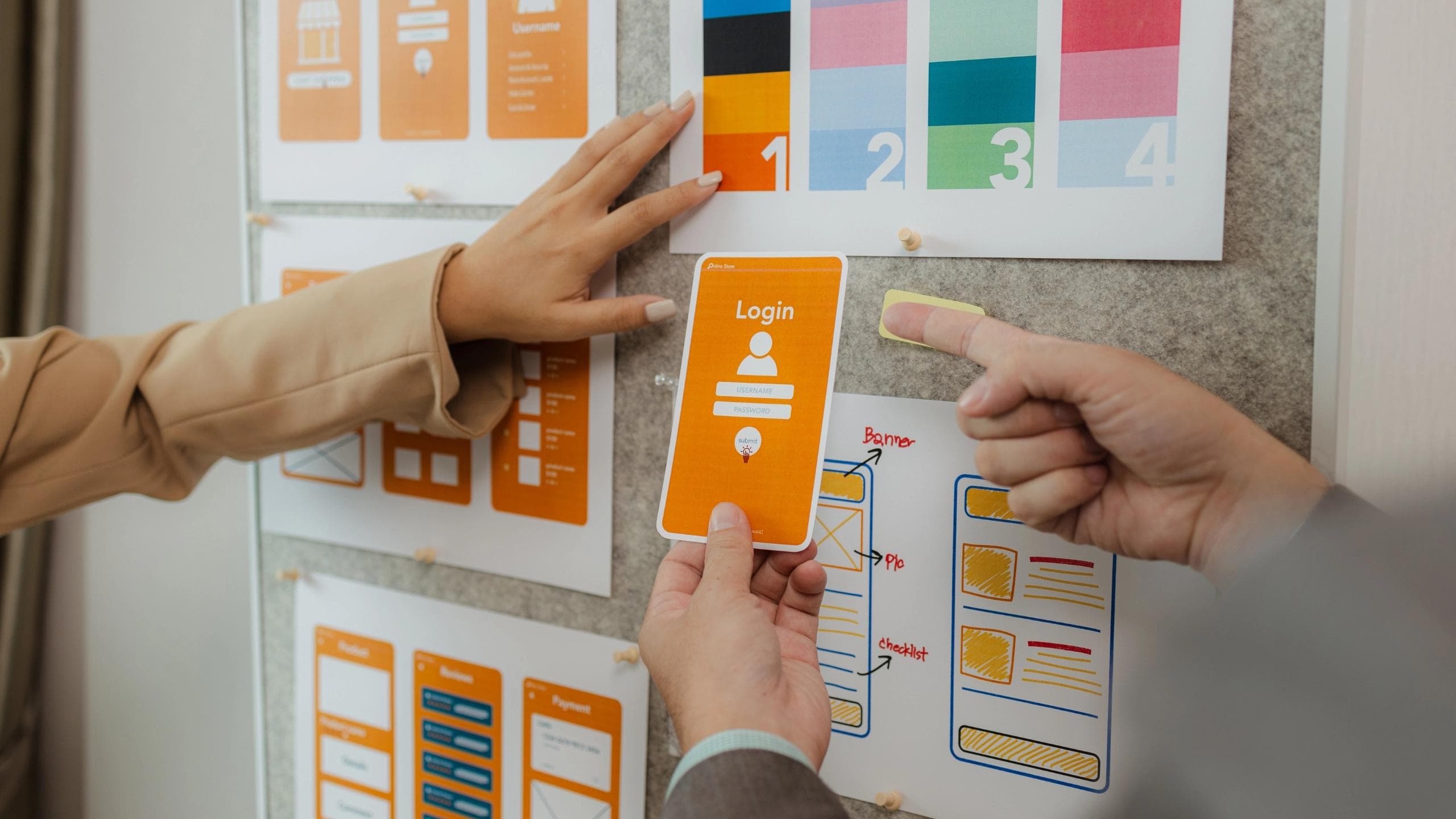 Designers reviewing and aligning mobile app wireframes and visual screens on a board, combining user flow structure with interface layout and visual design decisions.